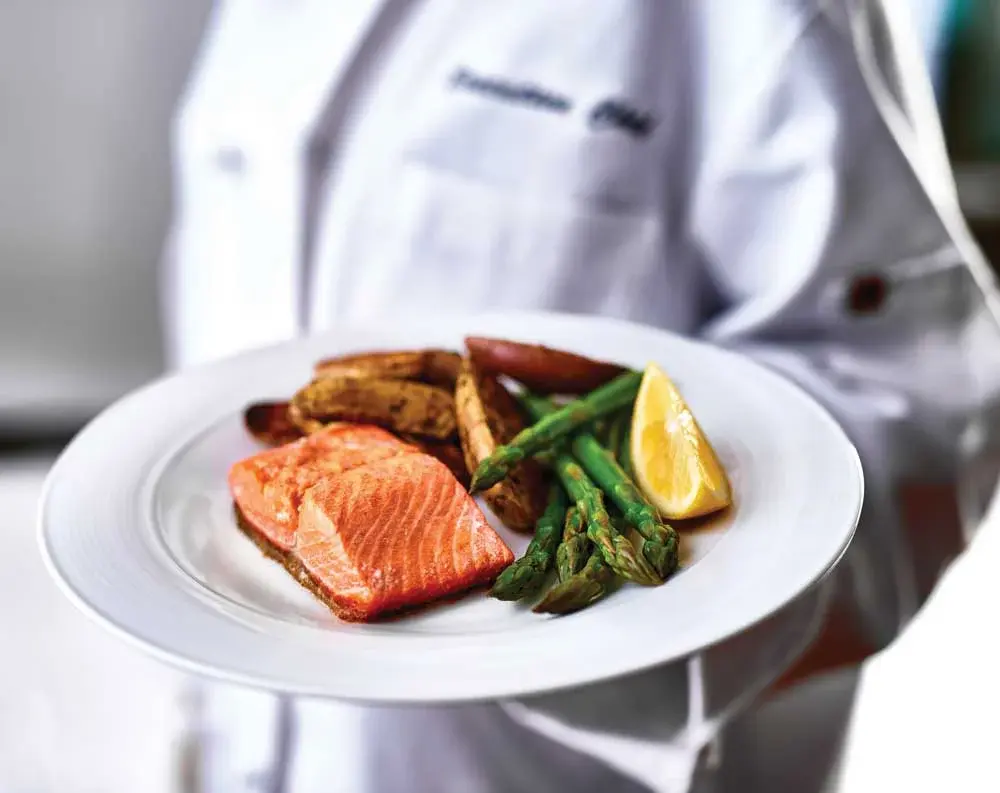 Summit Glen Chef Created Meals, chef delivering a finished dish.